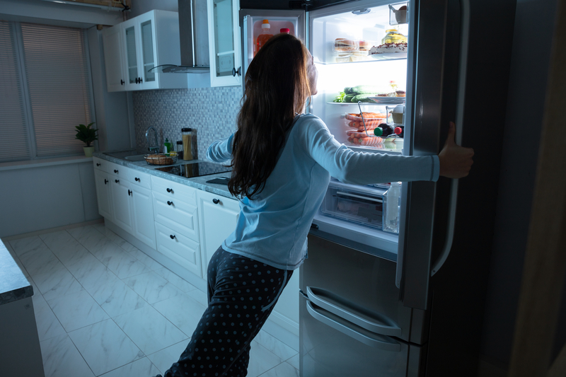 woman opening refrigerator door